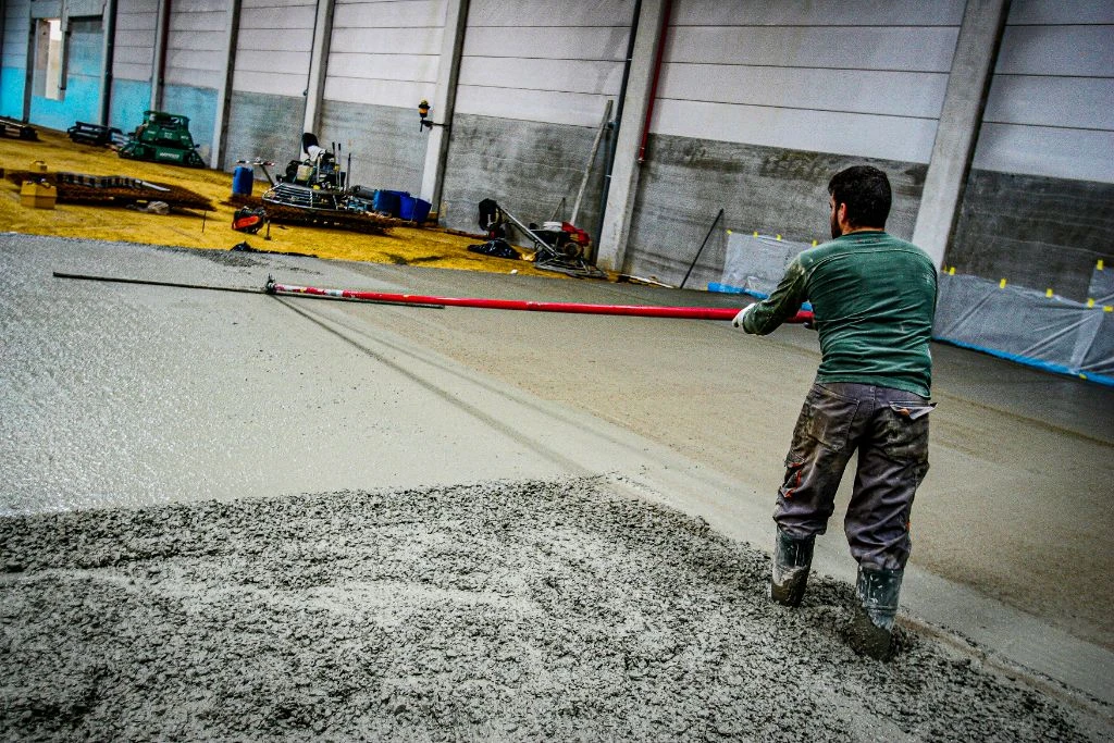Worker smoothing fresh concrete - finishing work