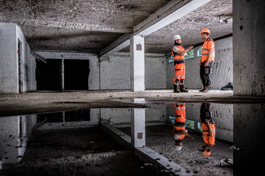 Teams on construction site - discussion in concrete interior