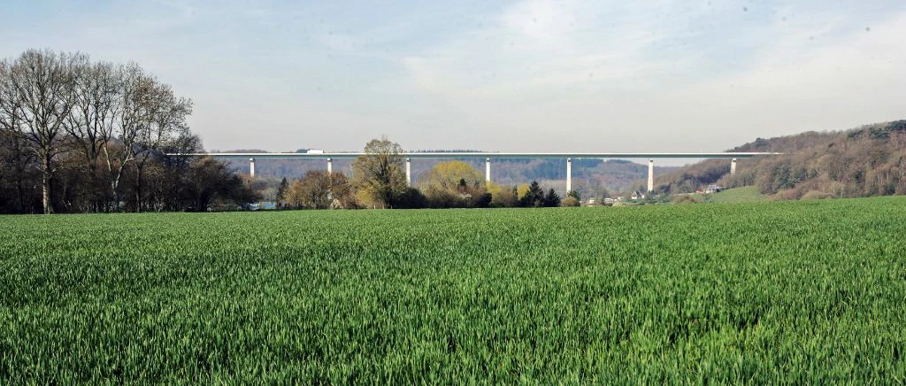 White viaduct in the distance with wheat field in foreground